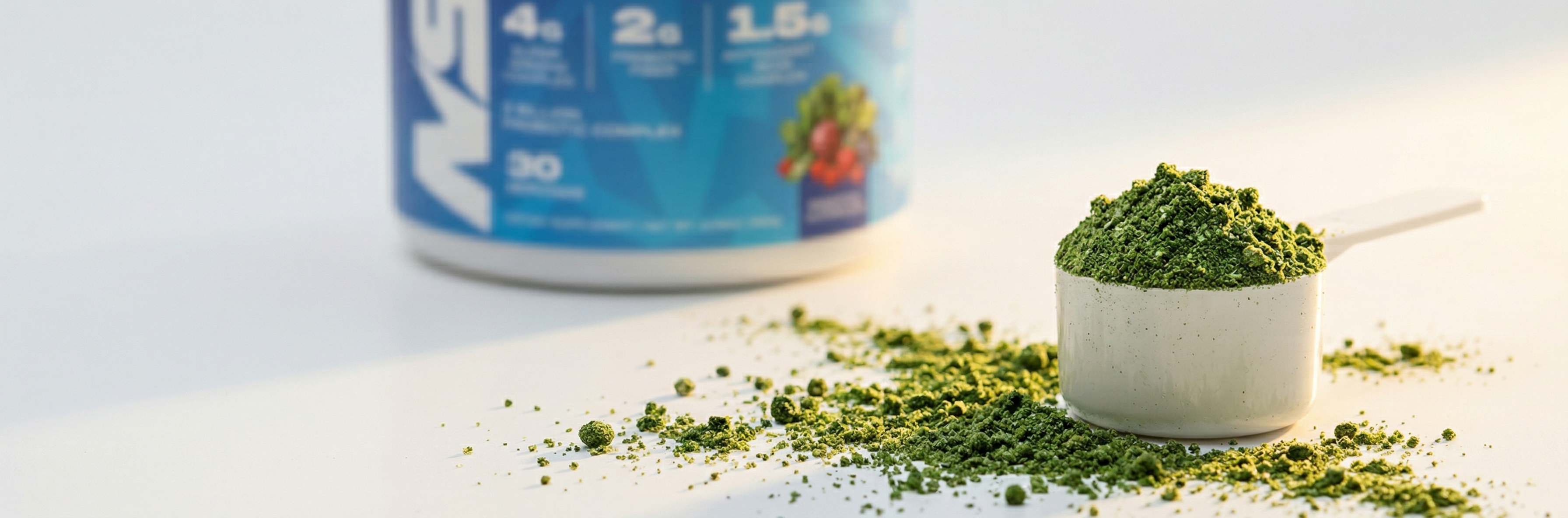 Close-up of NSP Superhuman Greens & Reds vibrant green superfood powder in measuring scoop — one scoop per serving